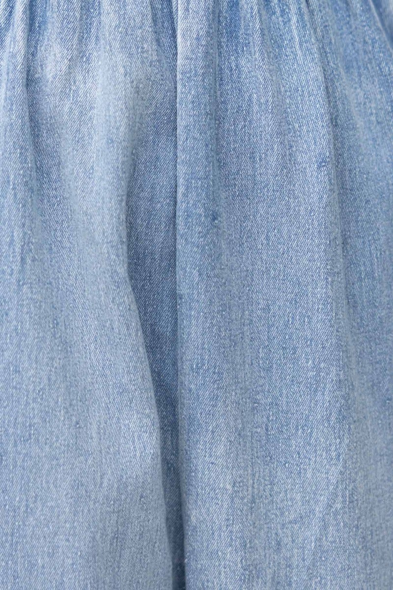 Close-up of soft denim fabric texture showcasing light blue tones for the Paddington Denim Jumpsuit.