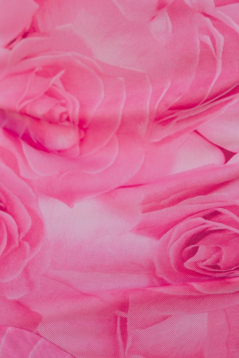 Close-up of pink floral fabric featuring roses, ideal for fashion design and textile applications.