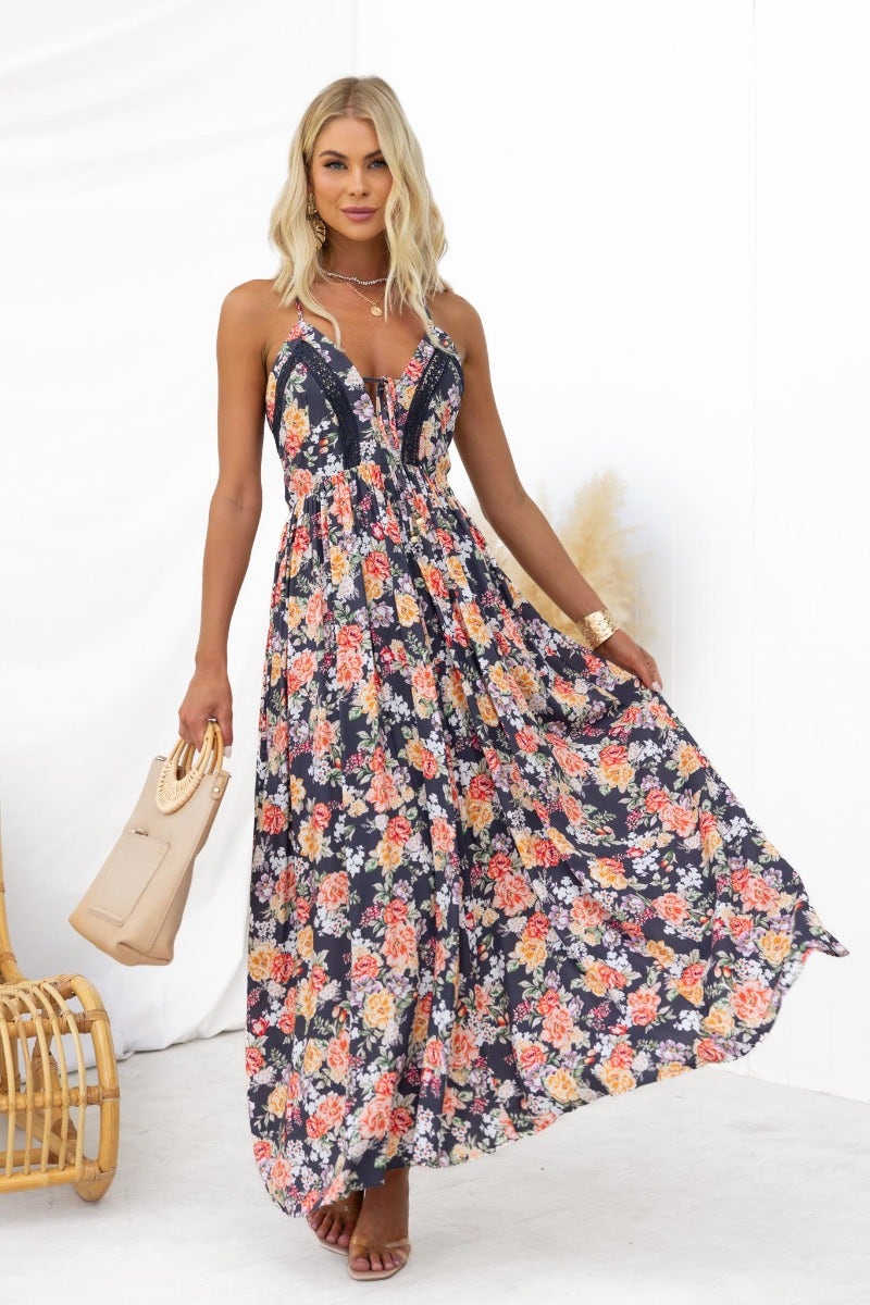 Montreal Maxi Dress: Floral print black dress with V-neckline, adjustable straps, and flowing skirt.