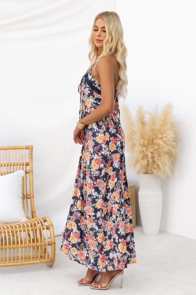 Montreal Maxi Dress: Black floral print, V-neckline, adjustable tie straps, and light material in elegant summer styling.