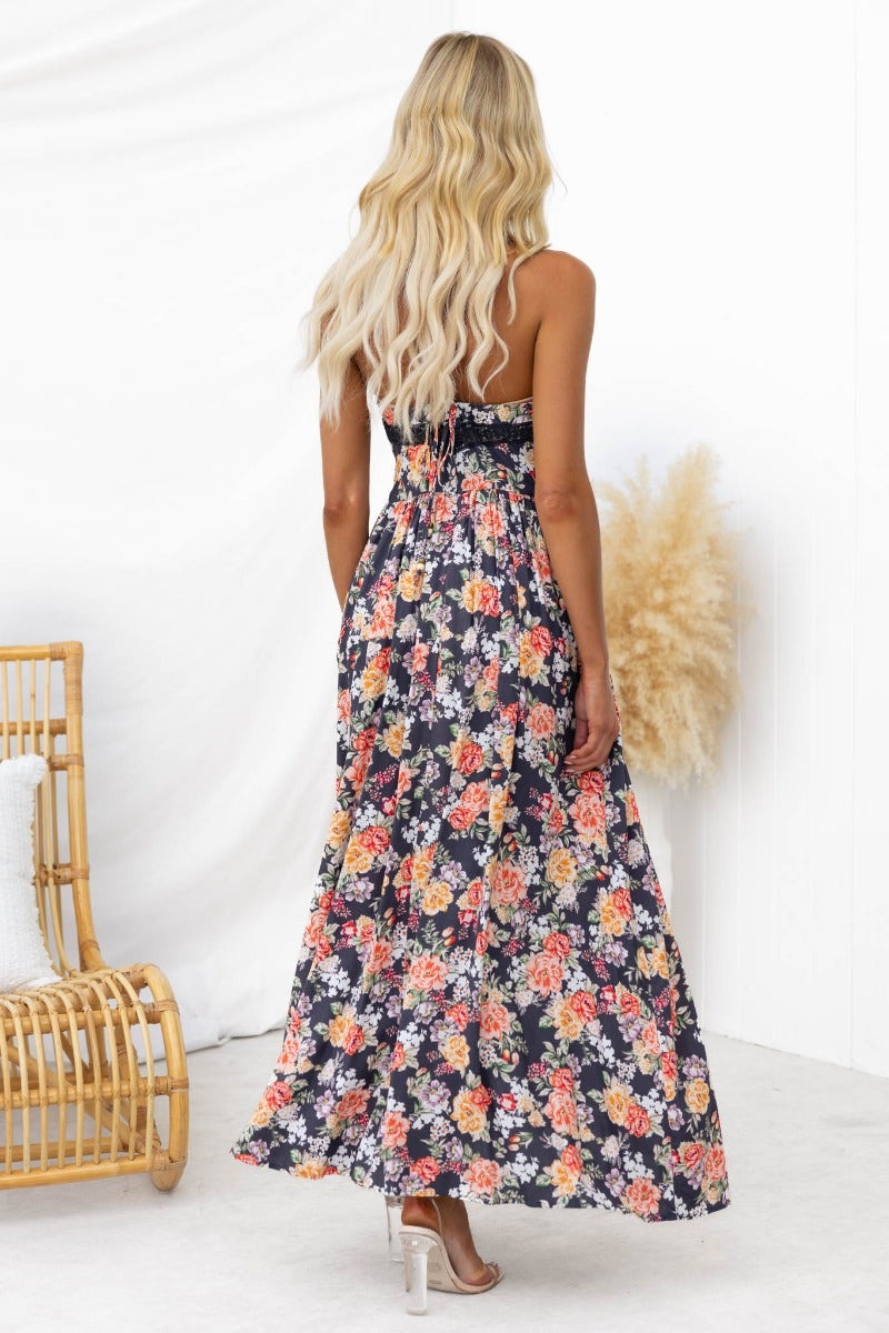 Back view of a floral print black maxi dress with adjustable straps and a V-neckline, perfect for summer outings.