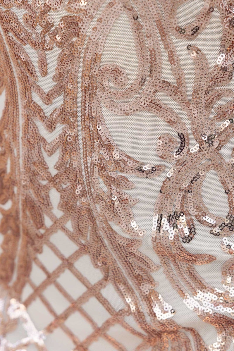 Close-up of sequin detail on luxurious maxi dress with intricate patterns in rose gold and mesh overlay.
