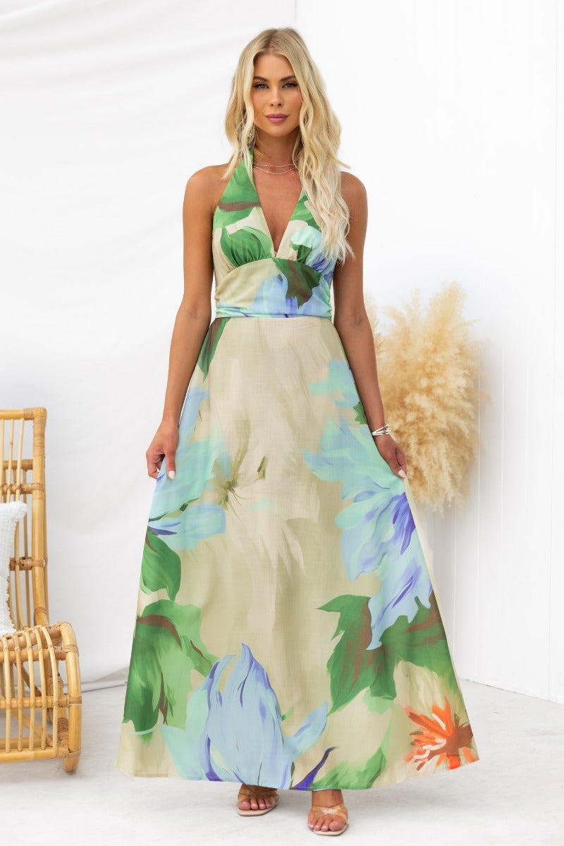 Model wearing the Better Off Maxi Dress, featuring a floral print, halter neck, and flowing design, perfect for summer occasions.