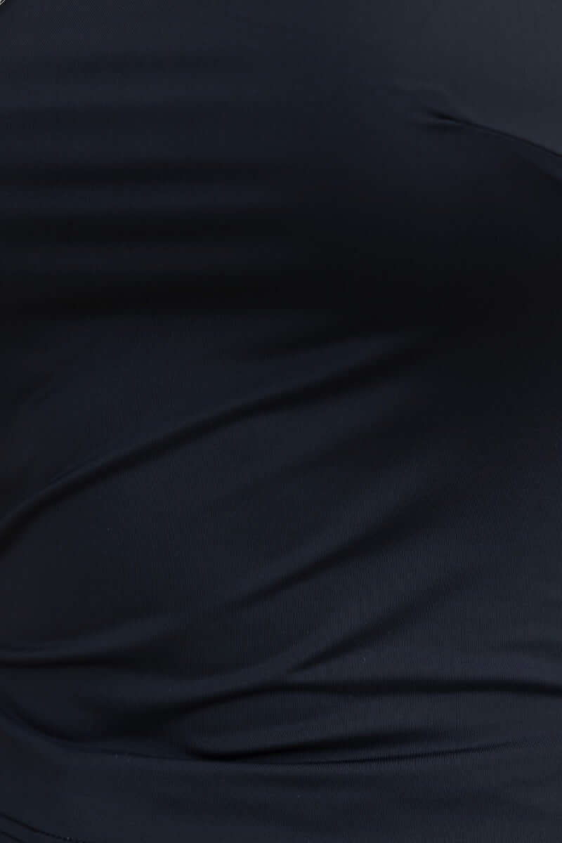 Close-up of black slinky top fabric with a square neckline and stretch material.
