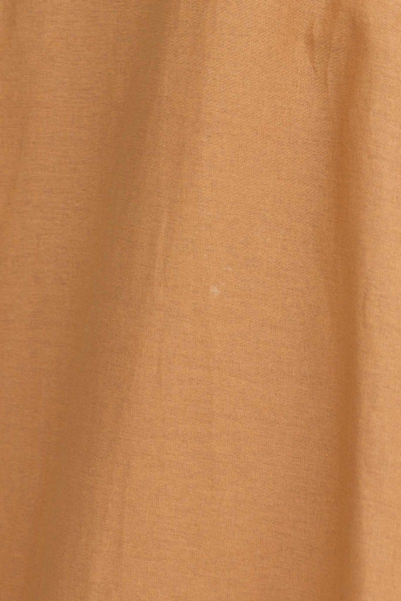 Close-up of textured brown fabric showcasing a cotton-like feel, ideal for clothing such as dresses.