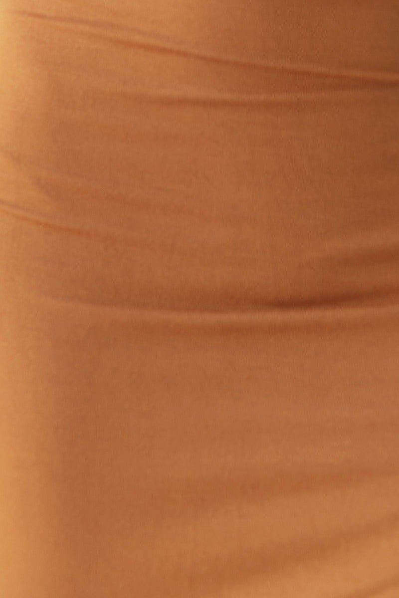 Close-up of soft, stretchy orange fabric of a bodycon midi dress, showcasing texture and material quality.