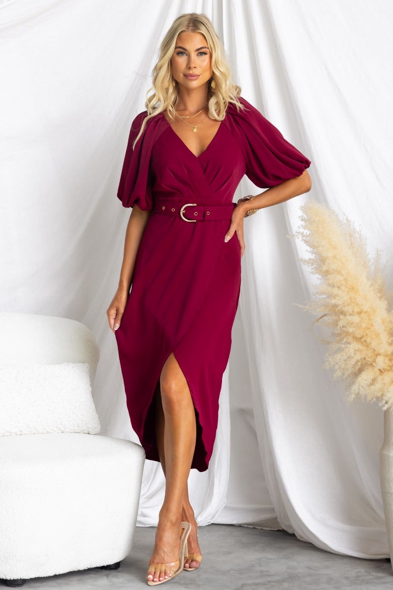 Model wearing a red Broadway Midi Dress with V-neckline, elastic sleeves, and a removable belt, styled against a neutral backdrop.
