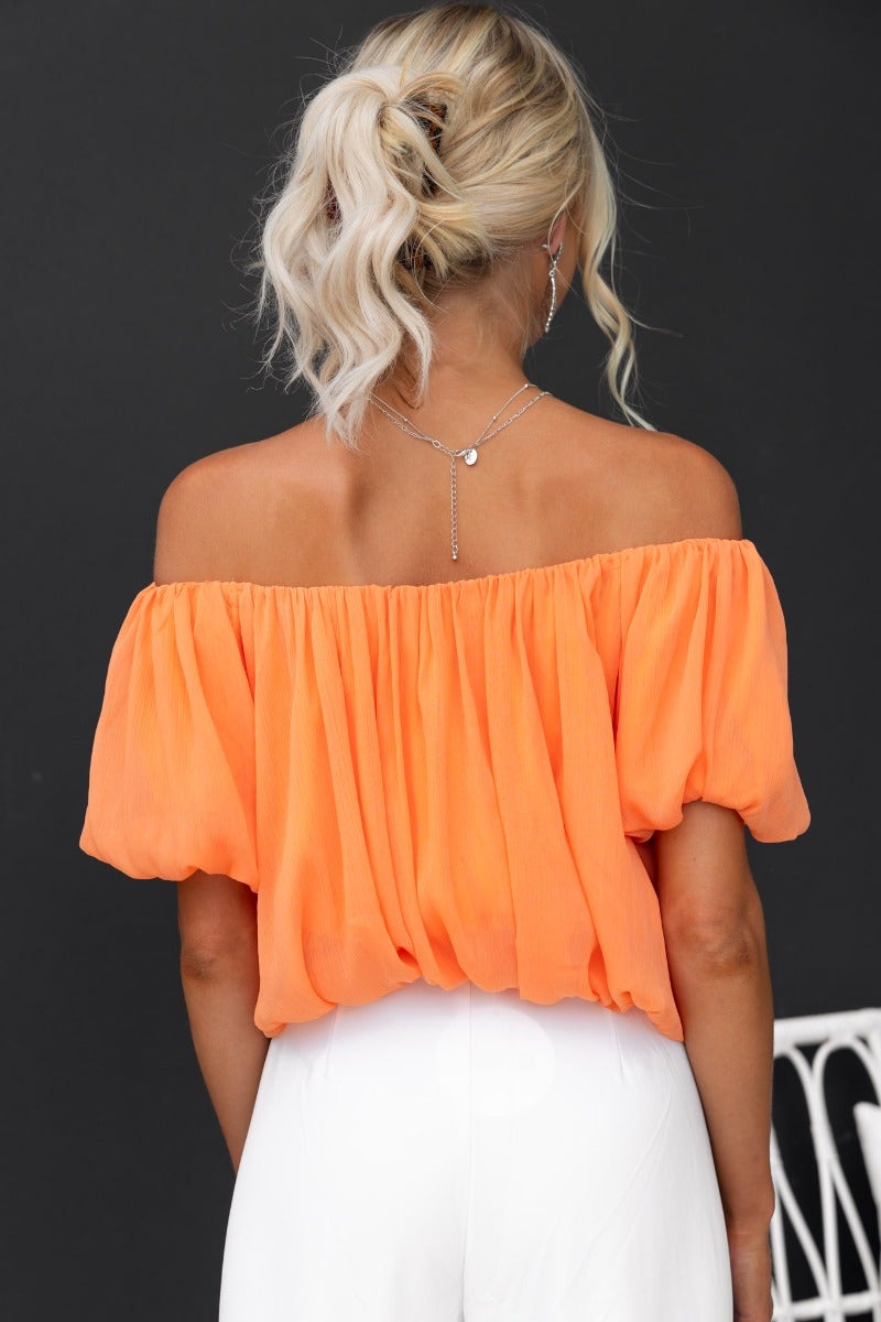 Adanna Top in vibrant orange, featuring an off-shoulder design and puff sleeves made of chiffon.