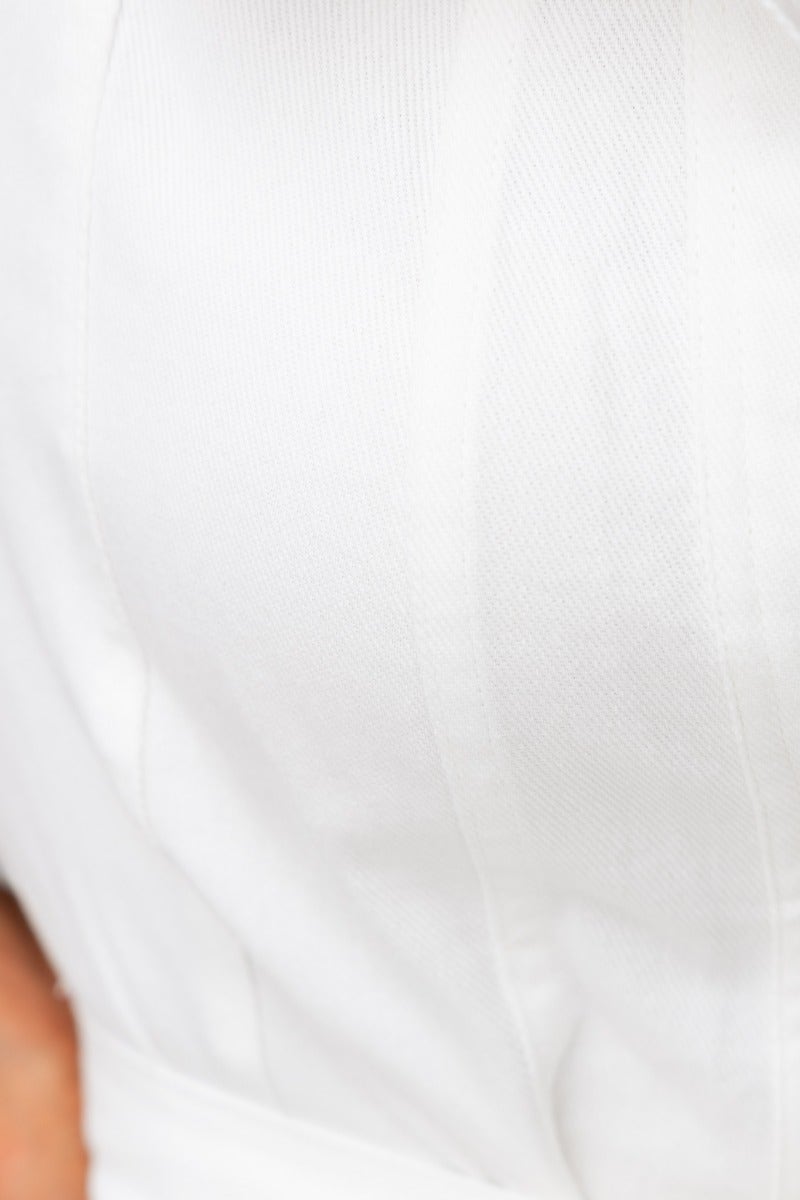 Close-up of the fabric texture of the Henry Denim Dress, showcasing the soft, stretchy material and crisp white color.