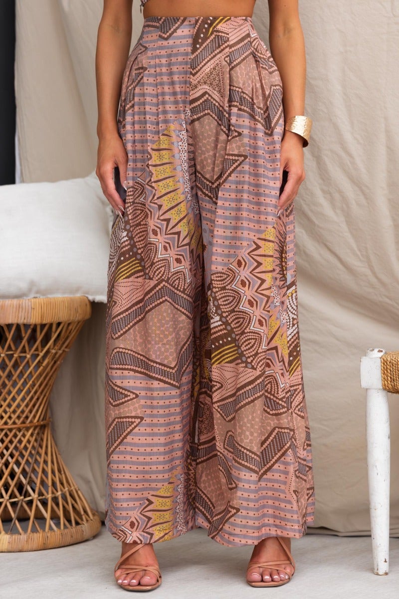 Halia pants with abstract print, mid-high waist, pockets, and light material, stylishly worn by model.