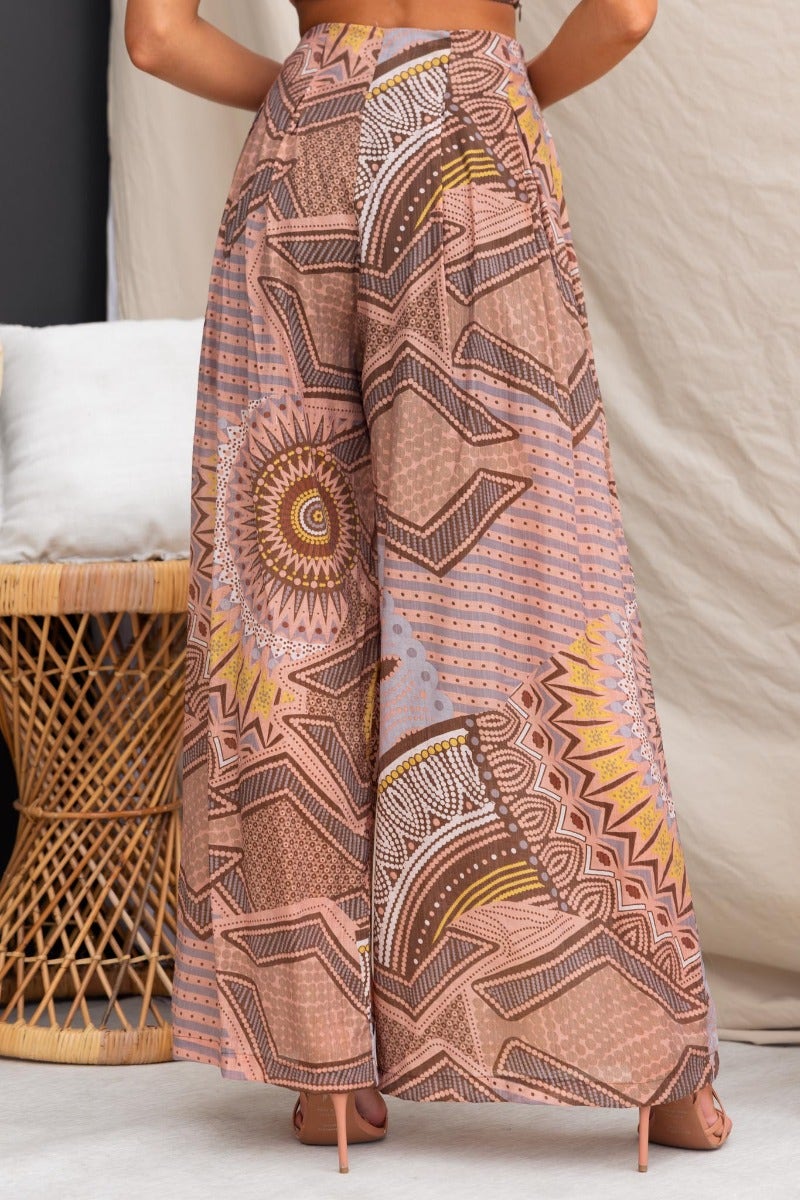 Halia Pants featuring an abstract print, mid-high waist fit, and wide legs, styled with a boho chic background.