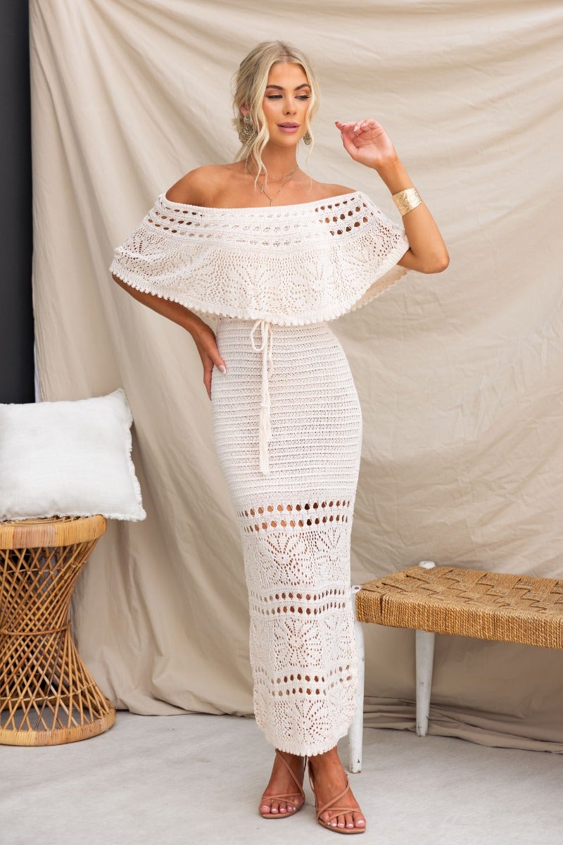 Model wearing Elva Maxi Dress with off-shoulder neckline, drawstring tie at waist, and crochet material.
