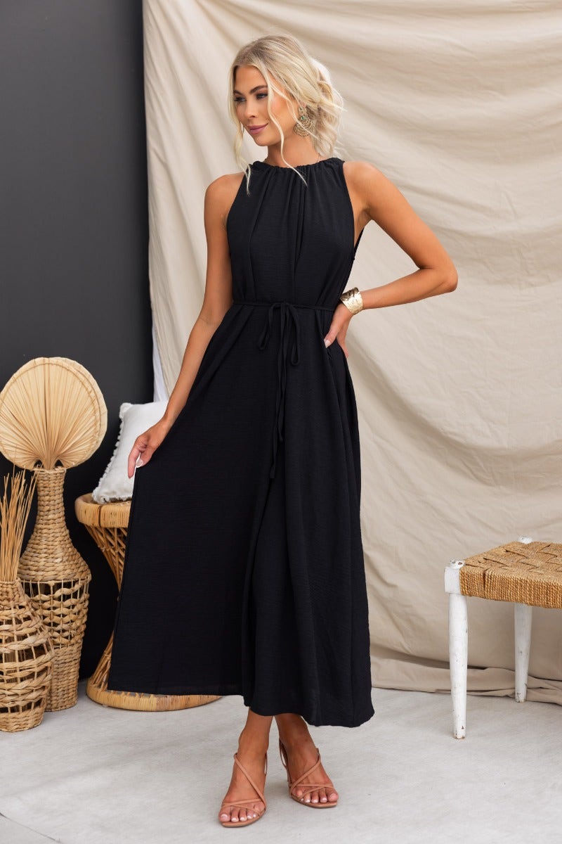 Black Iwaki Maxi Dress with adjustable drawstring tie neckline, featuring pockets and a lightly textured material.