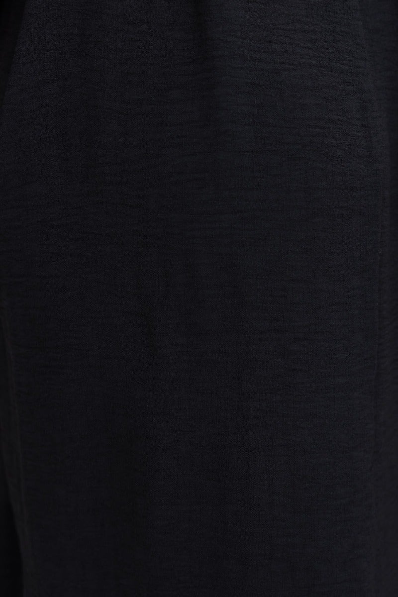 Close-up of the lightly textured black fabric of the Iwaki Maxi Dress, showcasing its stretch and quality.