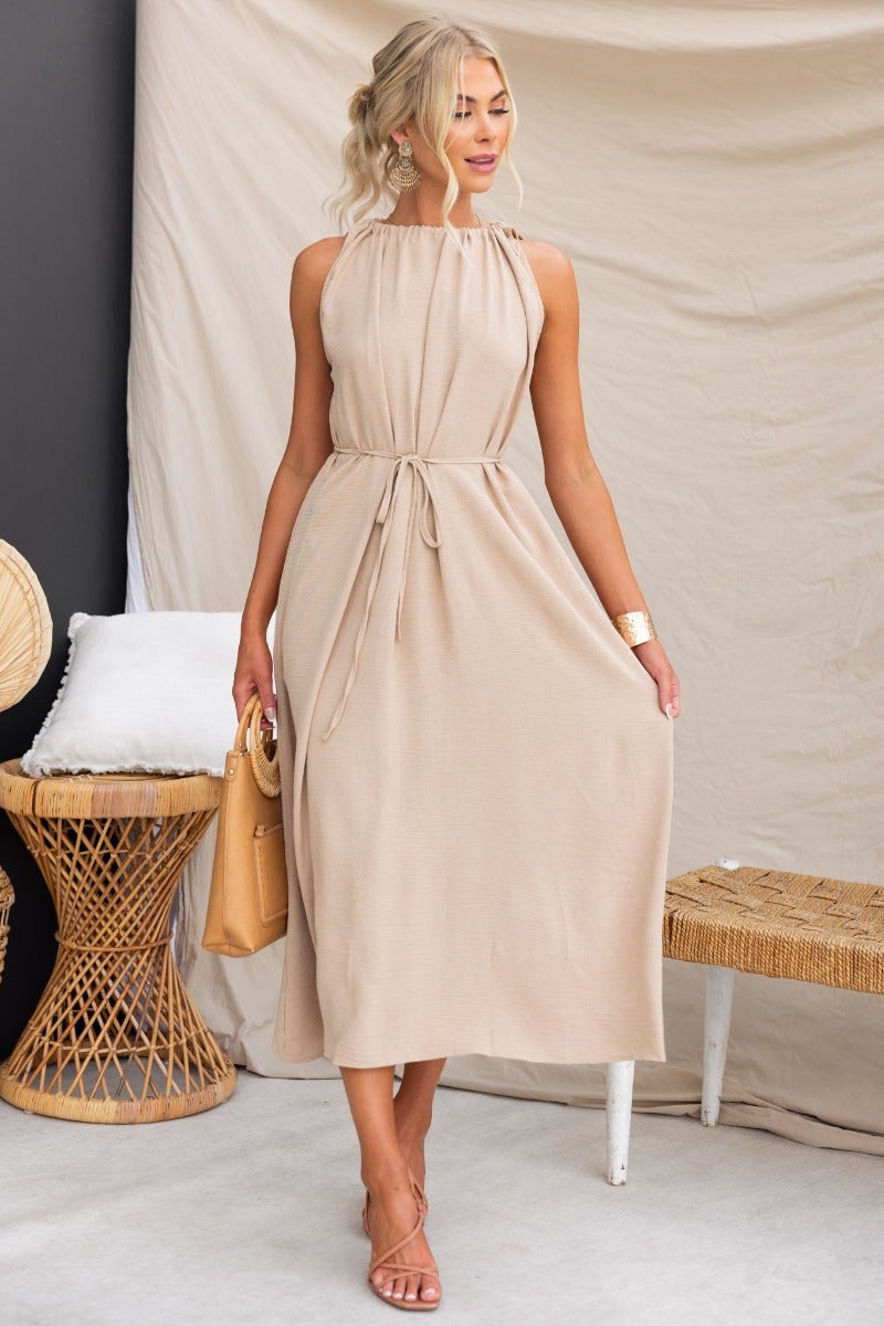 Model wearing Iwaki maxi dress with adjustable drawstring neckline, showcasing neutral color and effortless style.