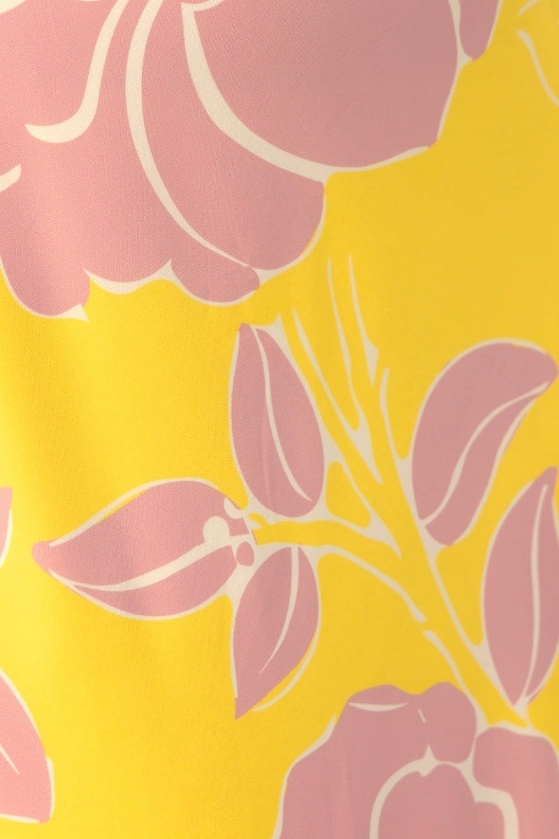 Close-up of floral print in shades of pink and white on a vibrant yellow background for Chirpy Maxi Dress.