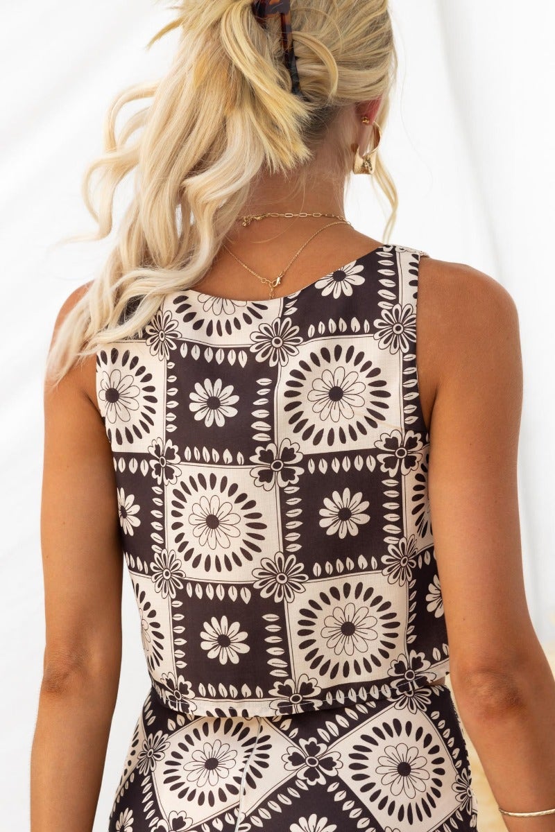 Back view of Theda Top featuring floral print design and square neckline, styled with blonde hair.