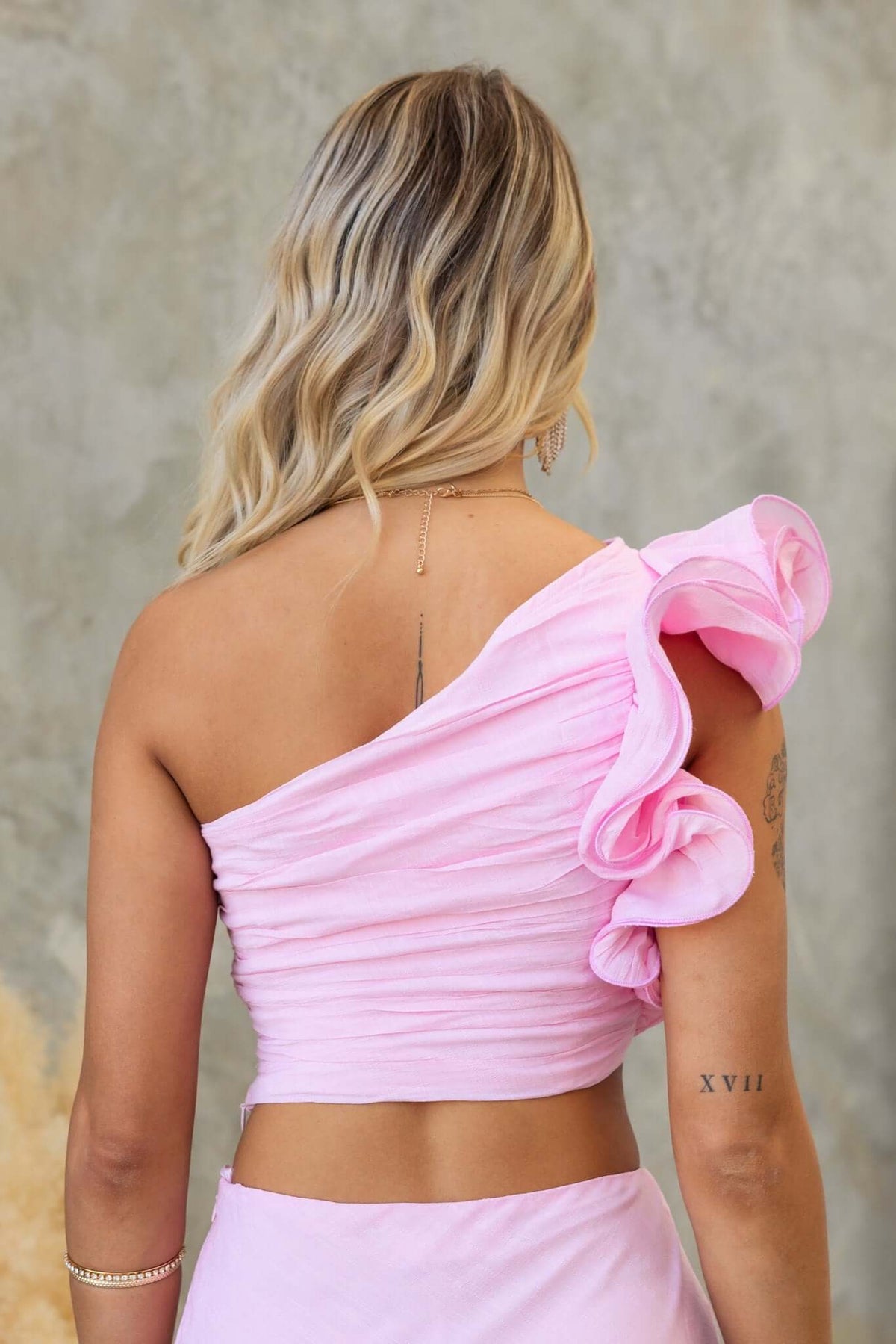 Back view of Meriden Top in pink chiffon with one-shoulder neckline and ruffle detail.
