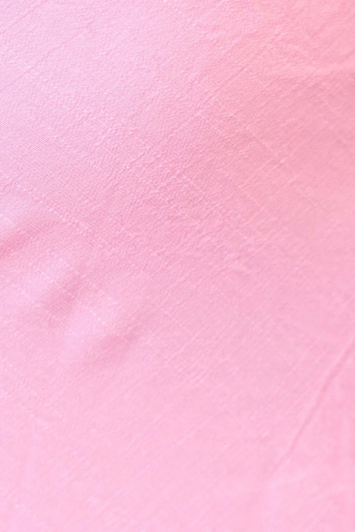 Close-up of soft pink chiffon fabric texture, ideal for a stylish one-shoulder top or elegant evening wear.