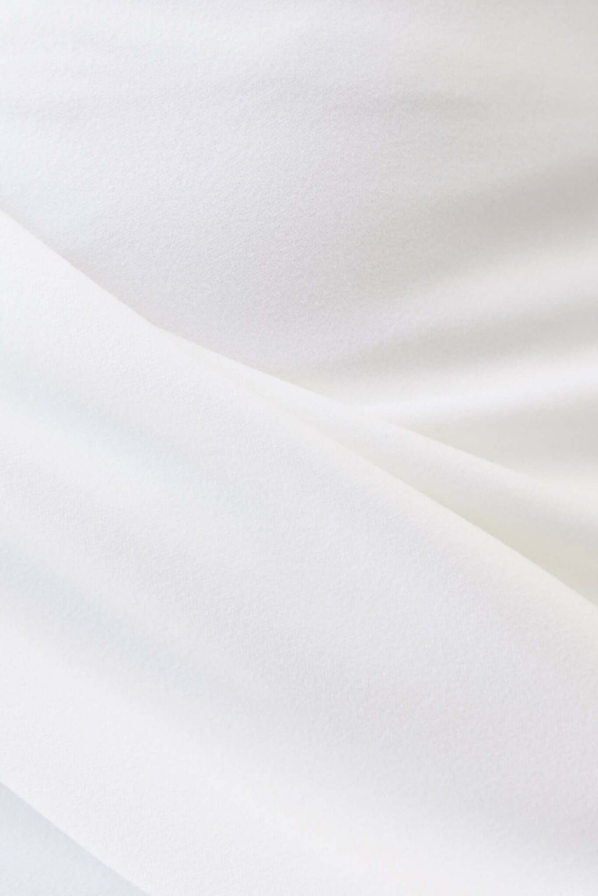 Close-up view of light, soft fabric showcasing the texture of a white Hemmie Midi Skirt.