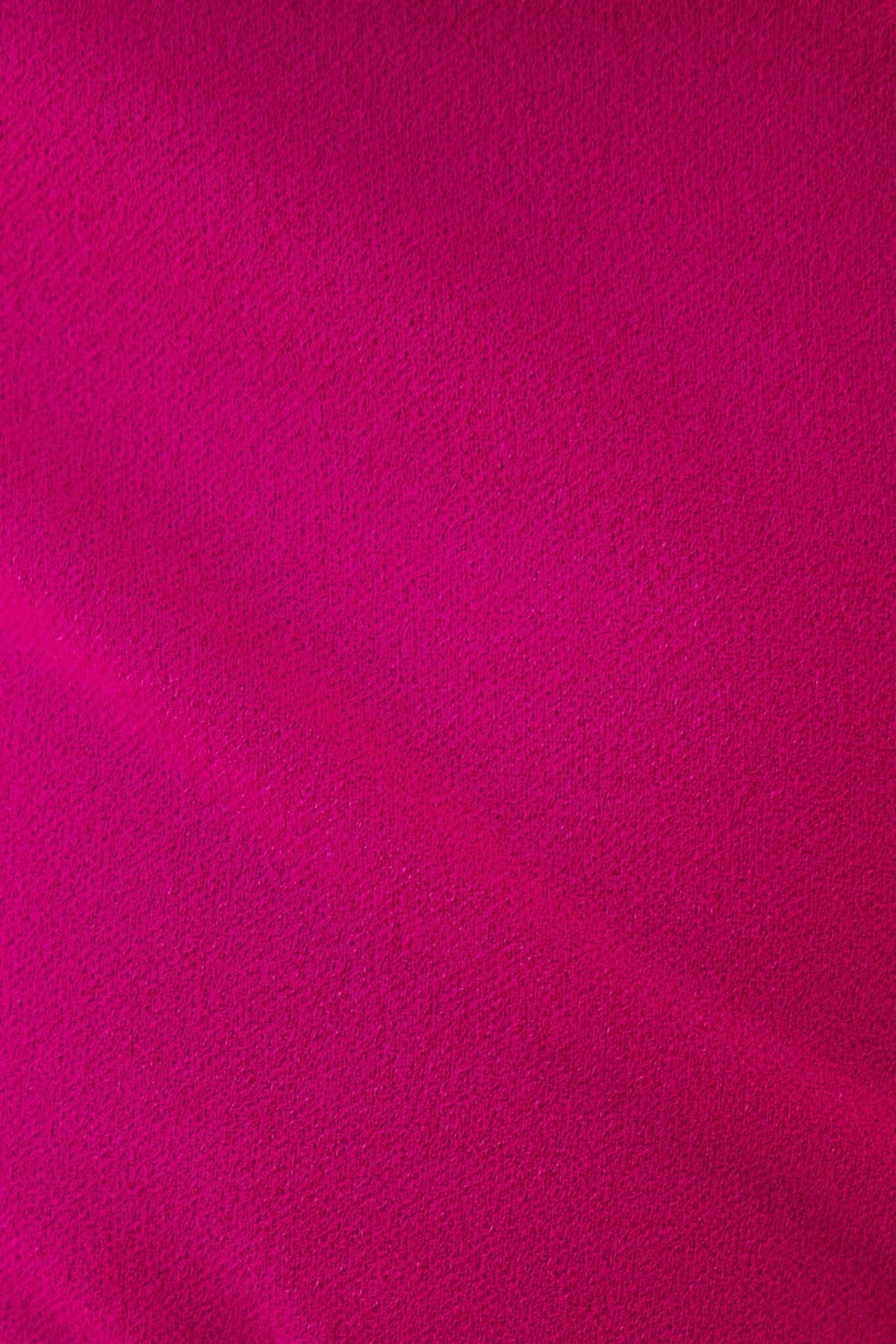 Close-up of vibrant fuchsia fabric texture used in the Bellar bodysuit, highlighting its soft and stretchy qualities.
