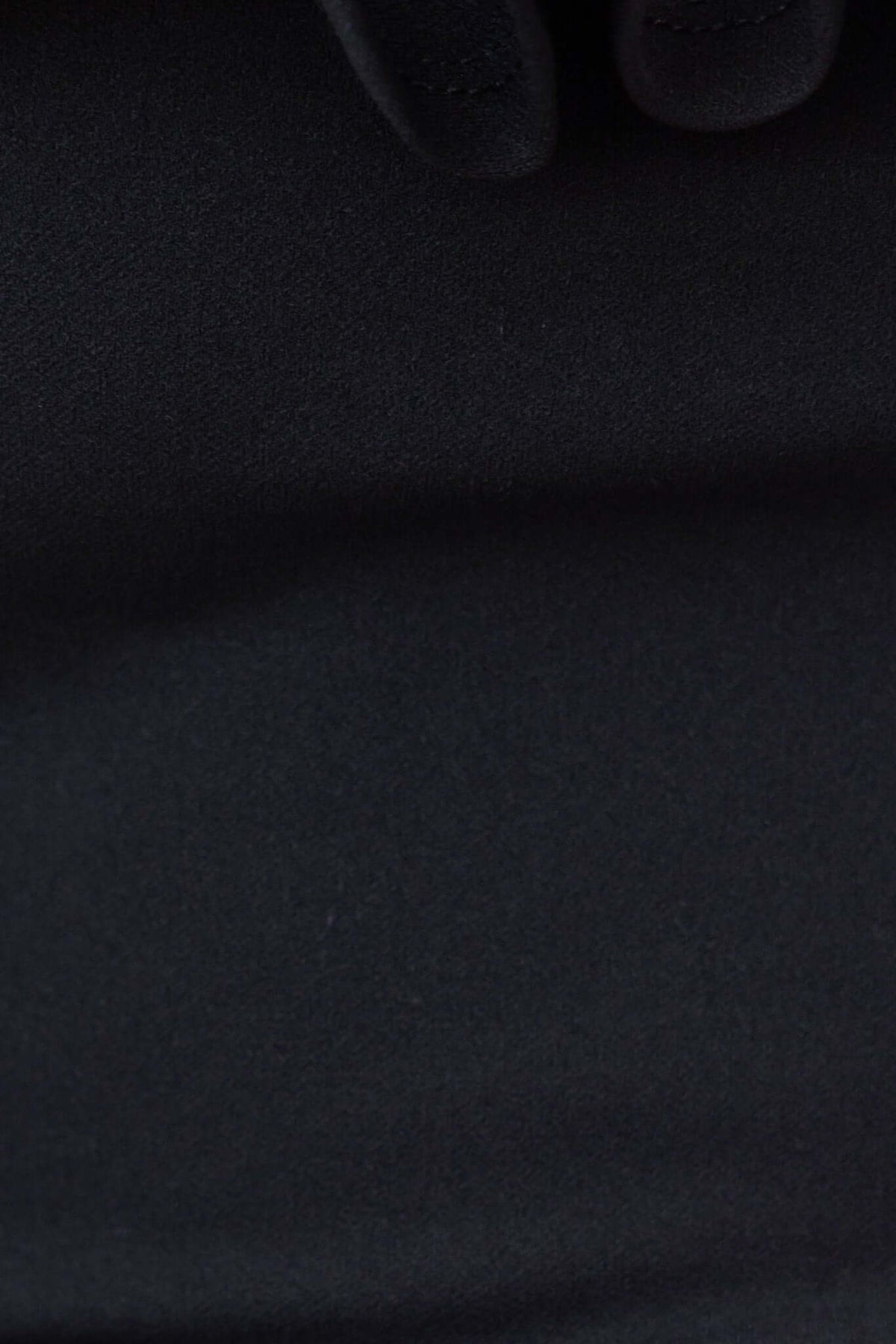 Close-up of black fabric showing smooth texture of the Bellar bodysuit, highlighting its stretch and quality.