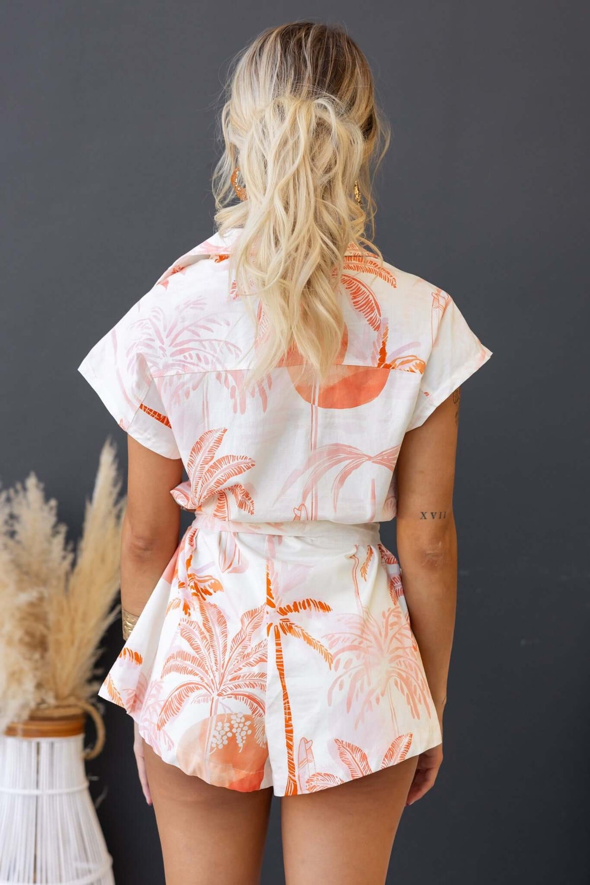 Back view of the Elaia Playsuit featuring a relaxed fit, collar, and tropical print design.
