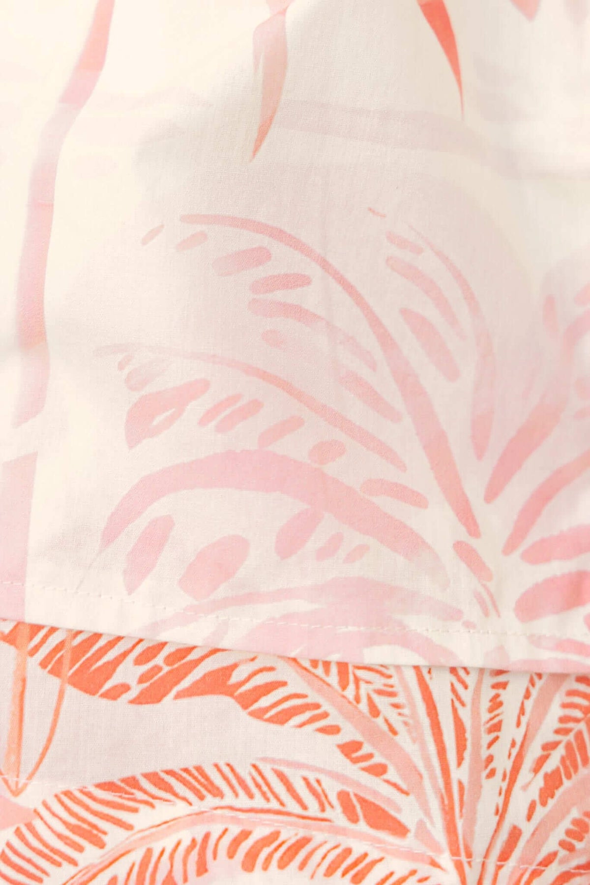 Close-up of Elaia Playsuit featuring a floral print in soft pink and coral tones.