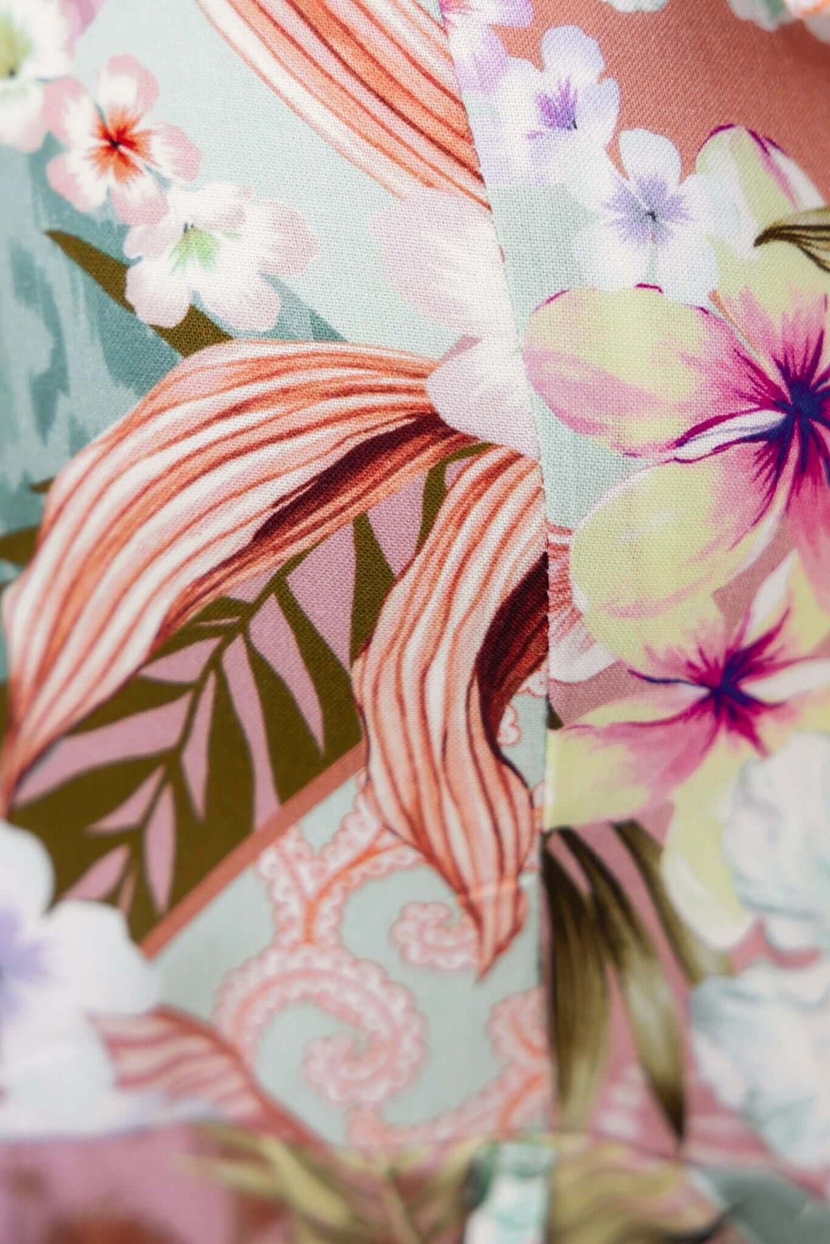 Close-up of vibrant floral fabric pattern on Taylin Playsuit, showcasing detailed leaves and blossoms.
