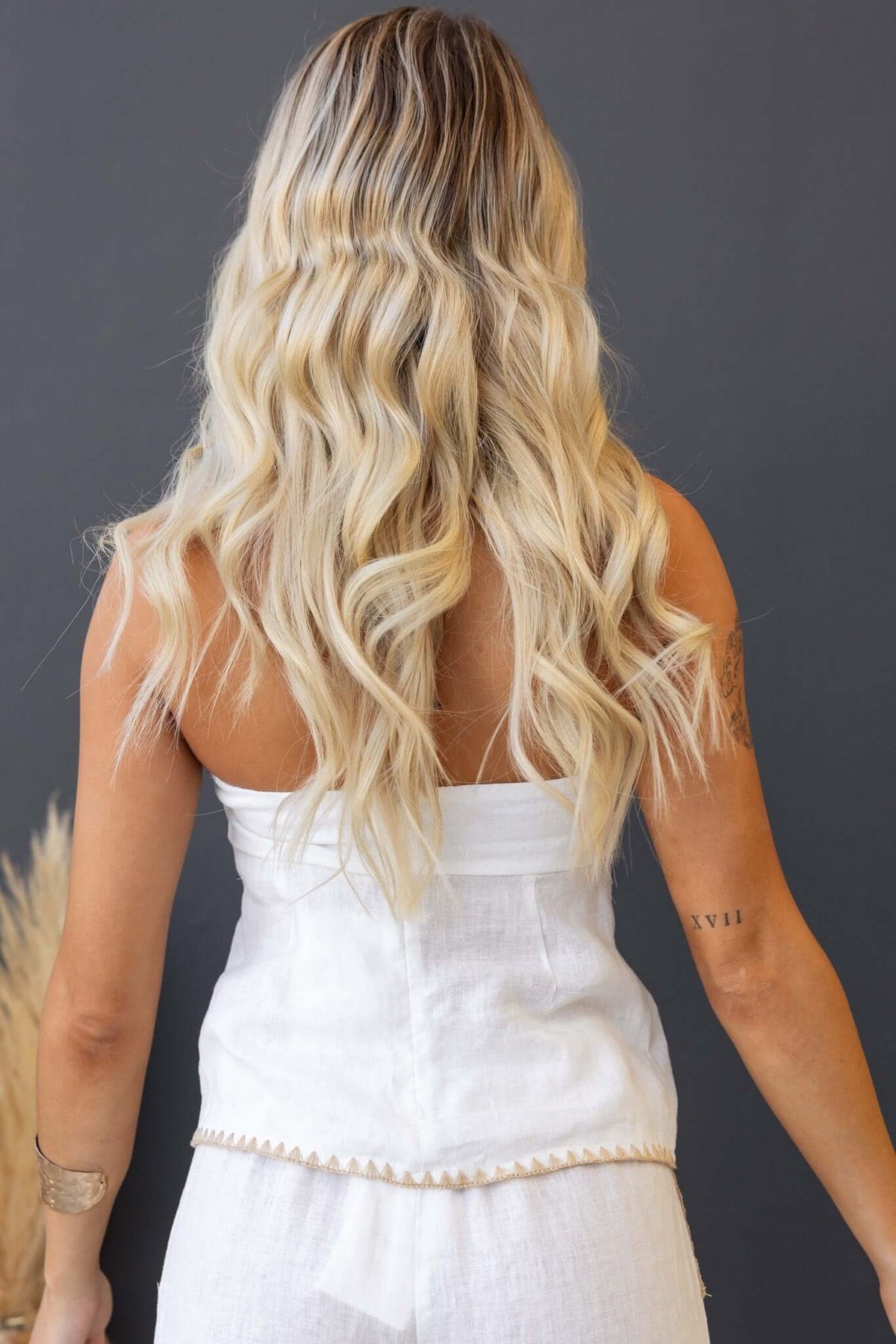 Rear view of a model wearing a strapless white Fraser Top, highlighting its anti-slip design and button-up front.