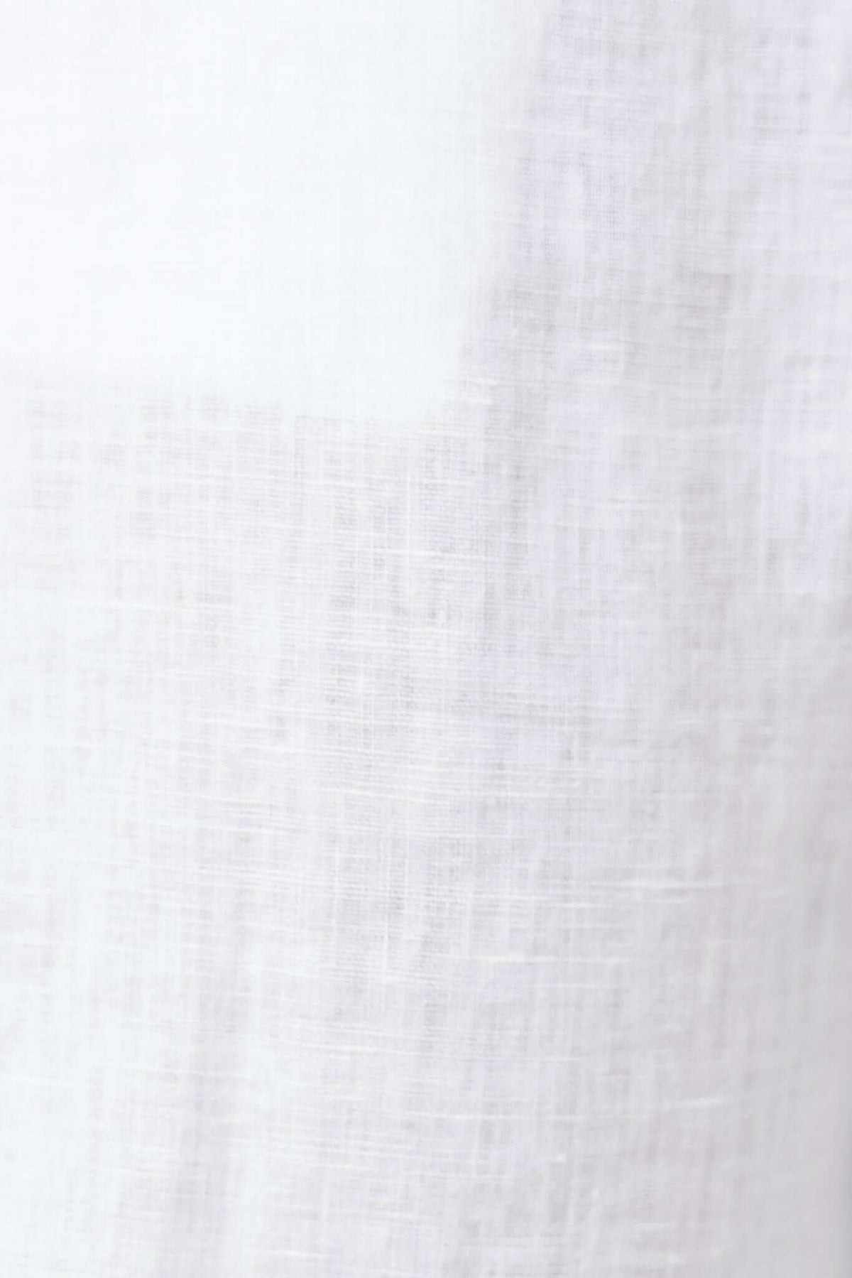 Close-up of lightweight, white linen fabric showcasing a soft texture, ideal for summer clothing.