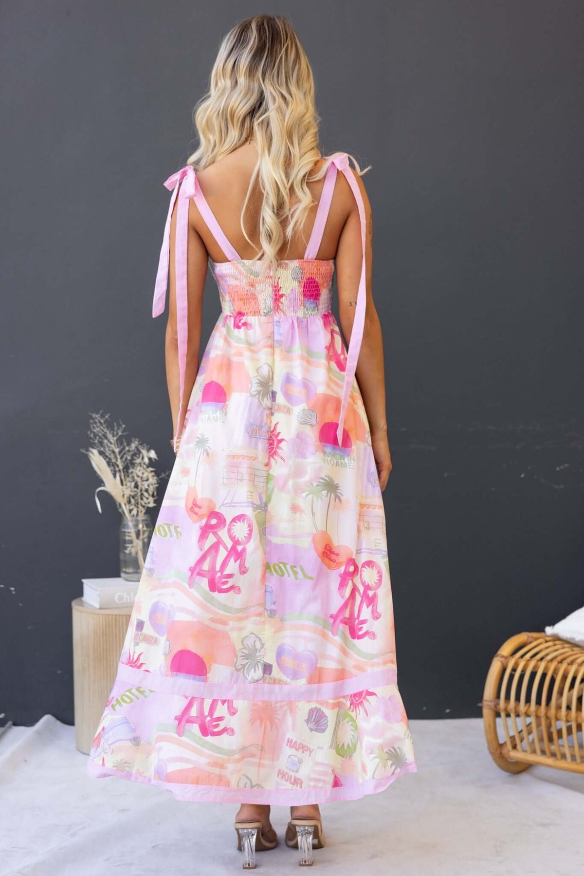 Back view of the Oreta Maxi Dress showcasing a colorful print, tie straps, and a flowing skirt.