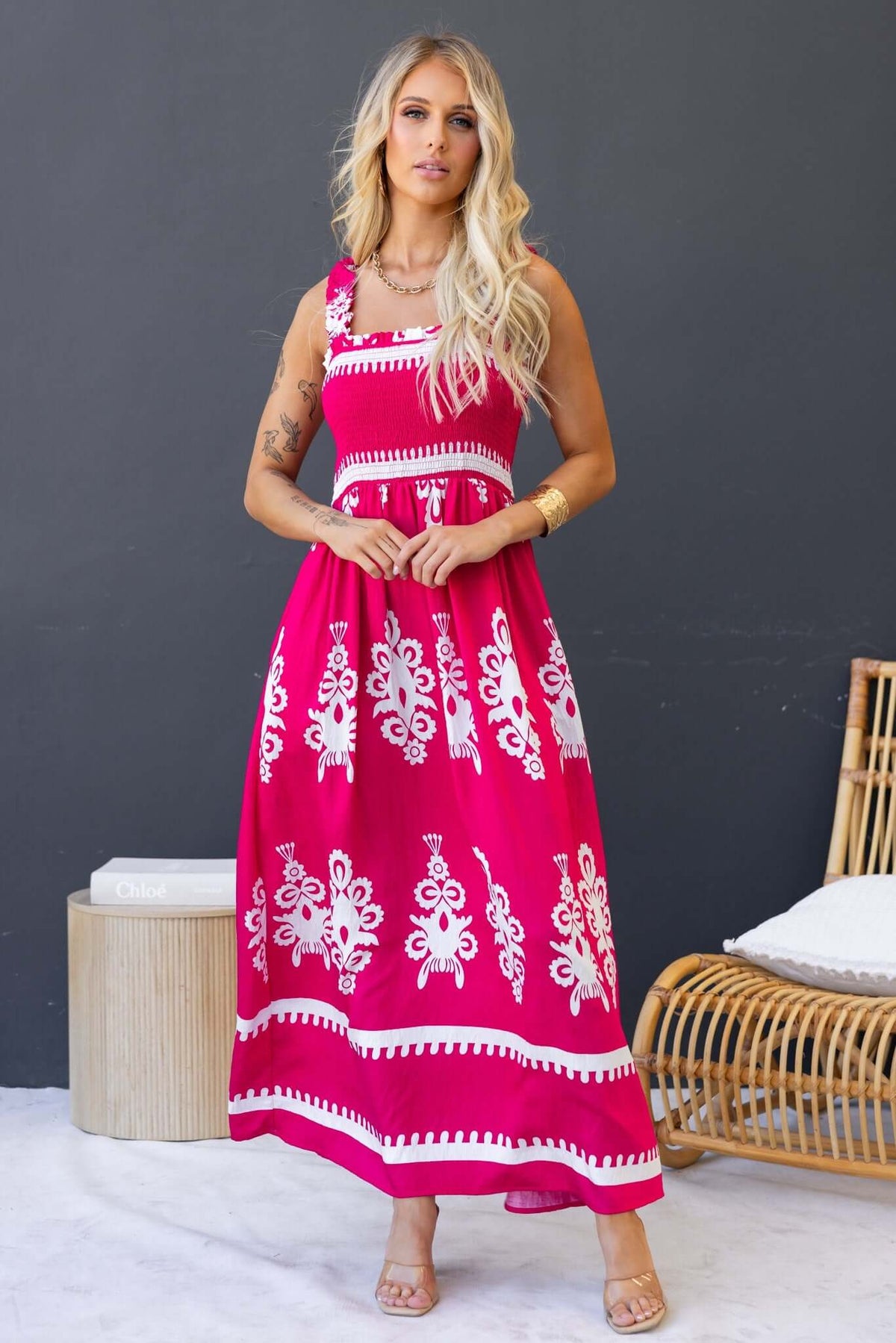 Model wearing a Summer Fields Maxi Dress in vibrant pink with white patterns, featuring a shirred bodice and pockets.