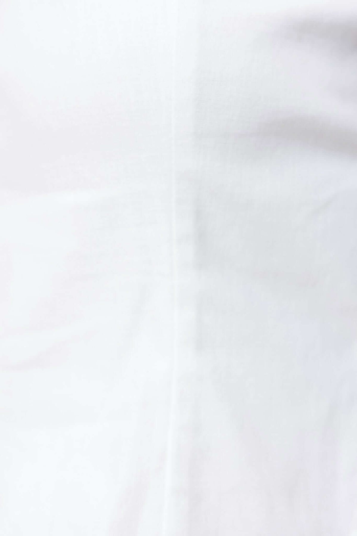 Close-up of the Pamela Top, featuring a clean button-up front with a cotton feel and smooth white fabric.
