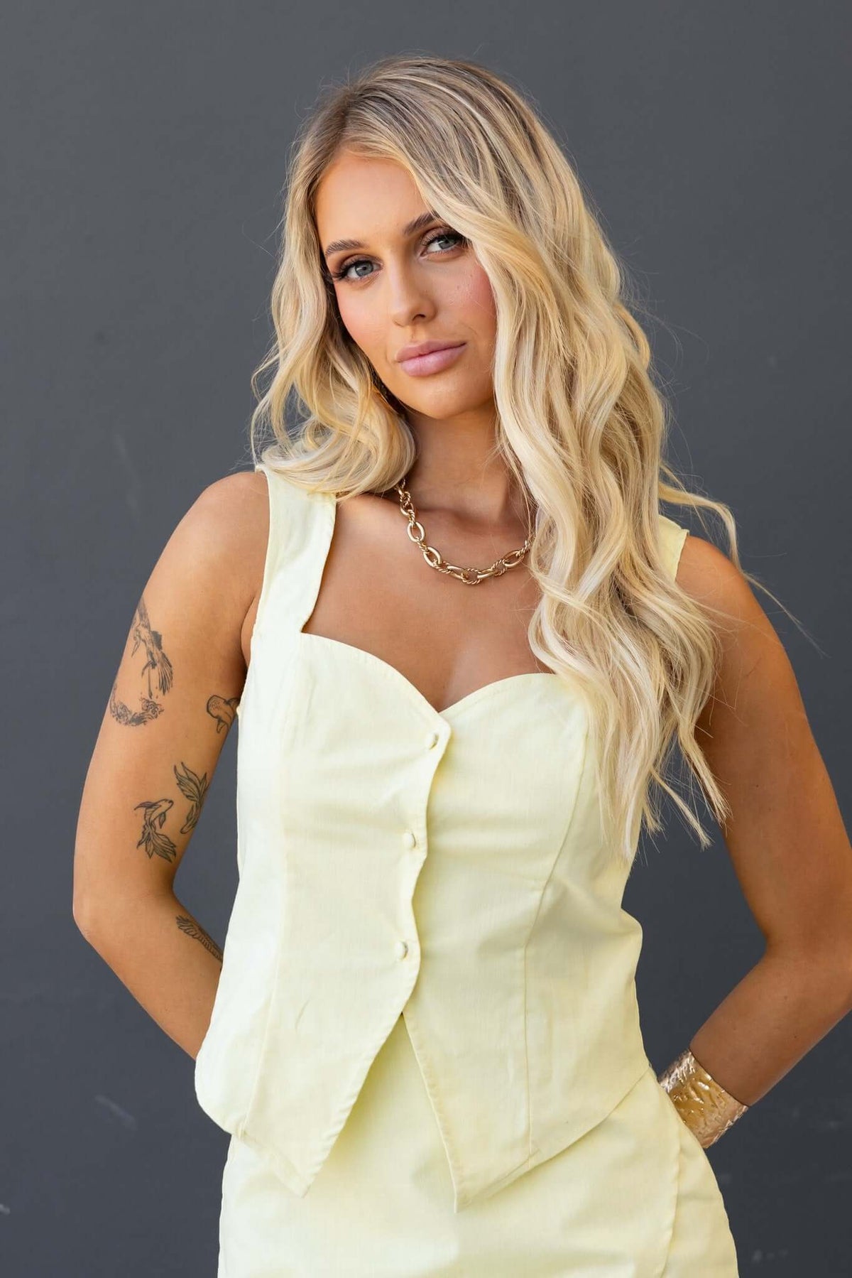 Pamela Top in soft yellow, featuring button-up front and stylish lined design, perfect for casual and chic looks.