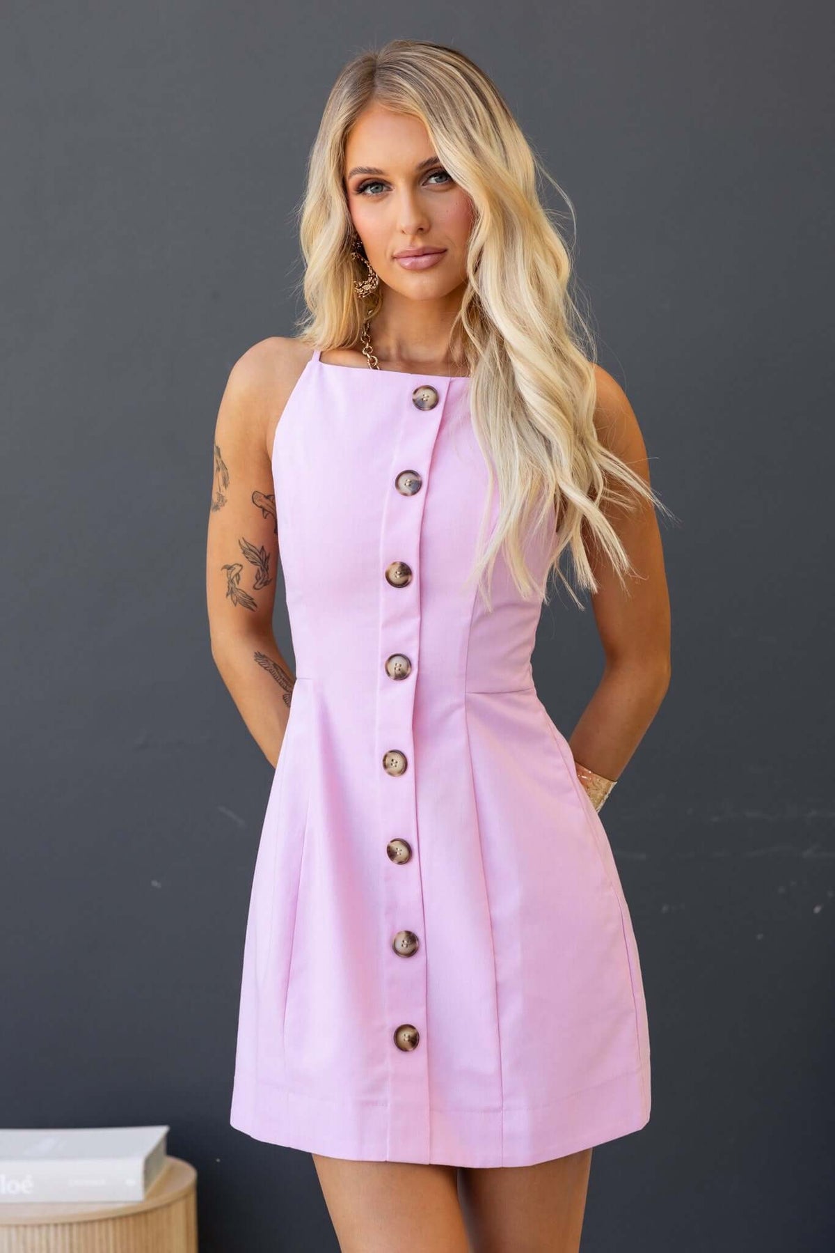 Olean Dress in soft pink with faux buttons and side invisible zip, worn by model with long hair and tattoos.