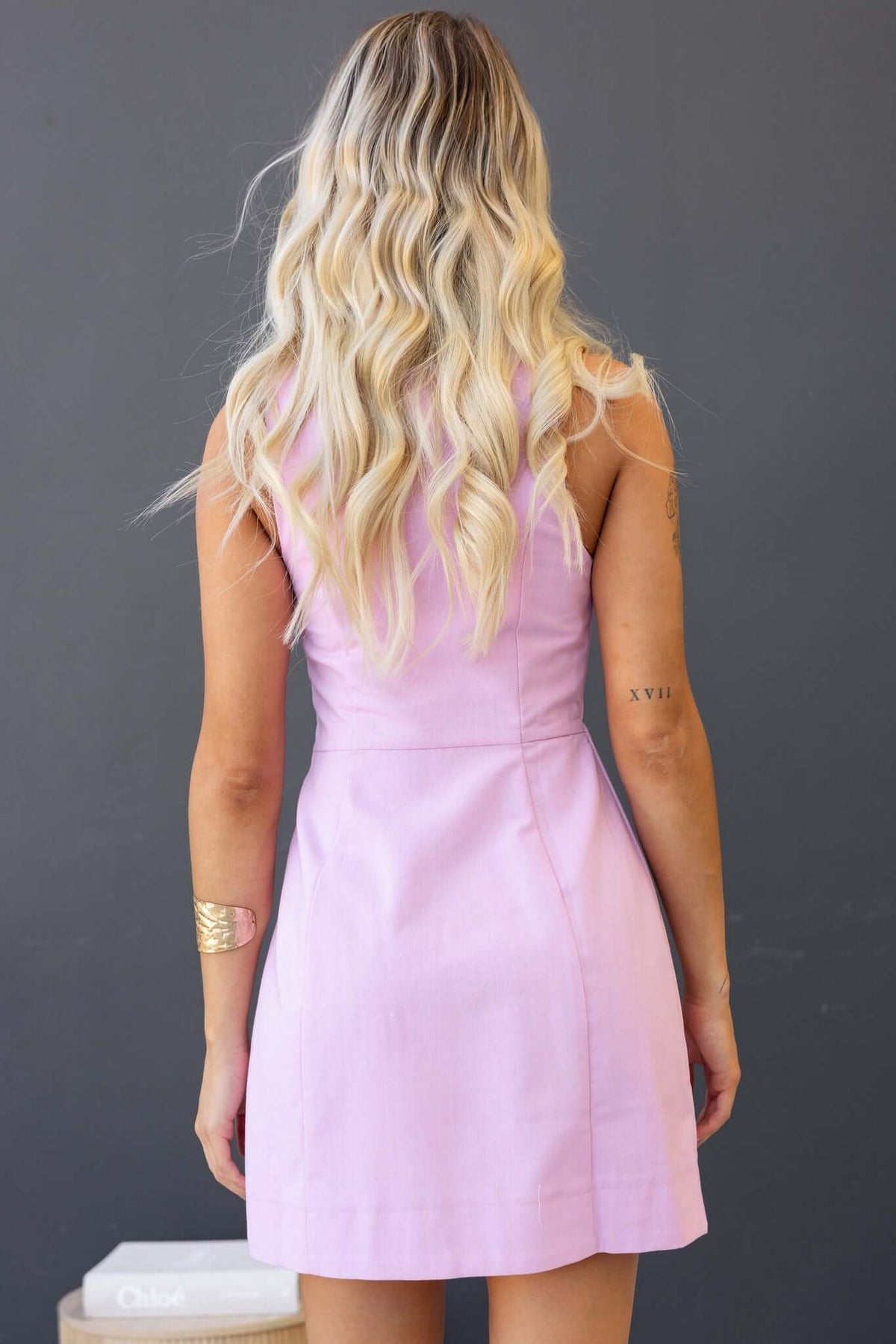 Back view of the Olean Dress in light pink, featuring faux buttons and a fitted silhouette.