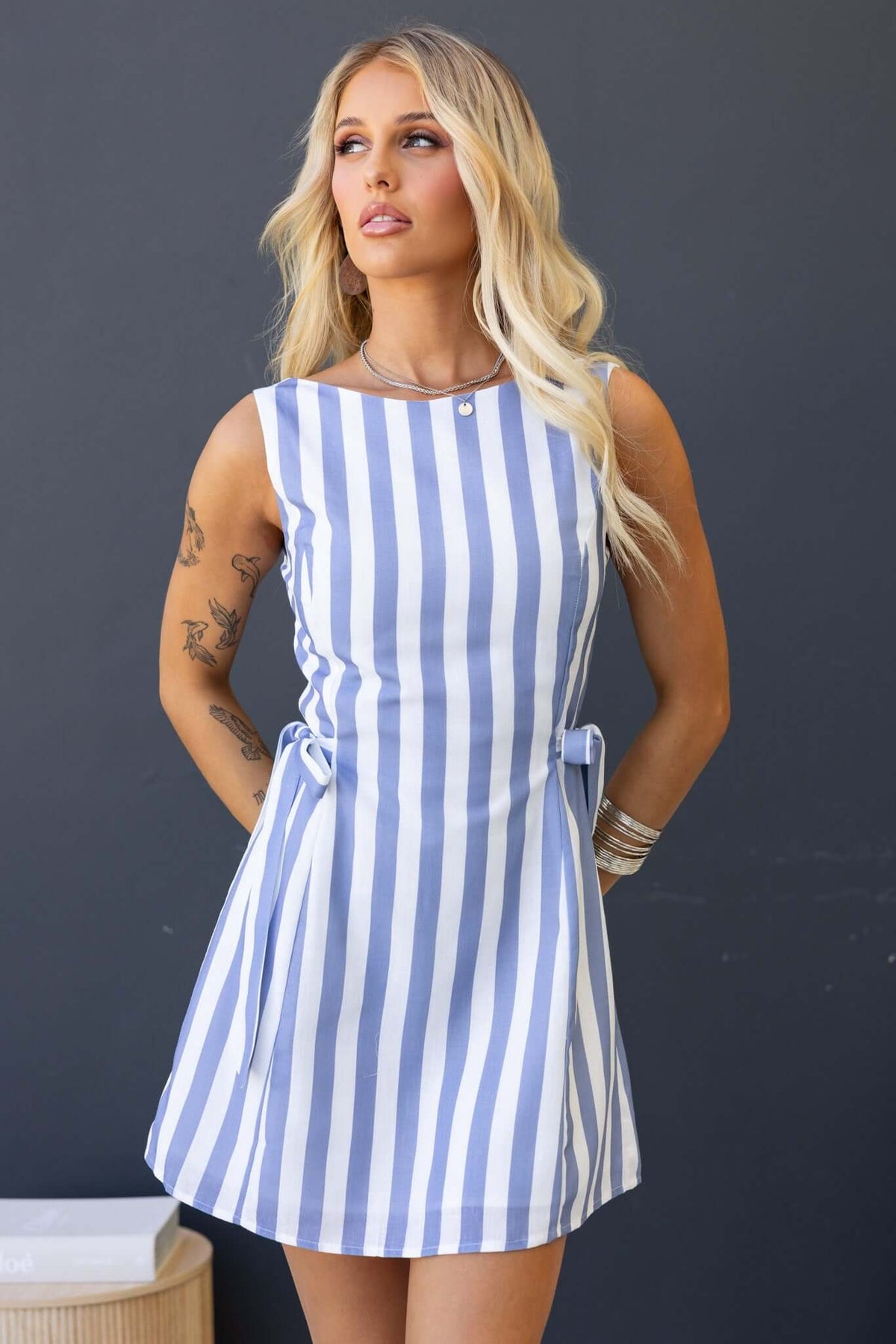 Stylish Cartwright Dress featuring blue and white stripes, low-cut back, and tied sides, perfect for summer outings.