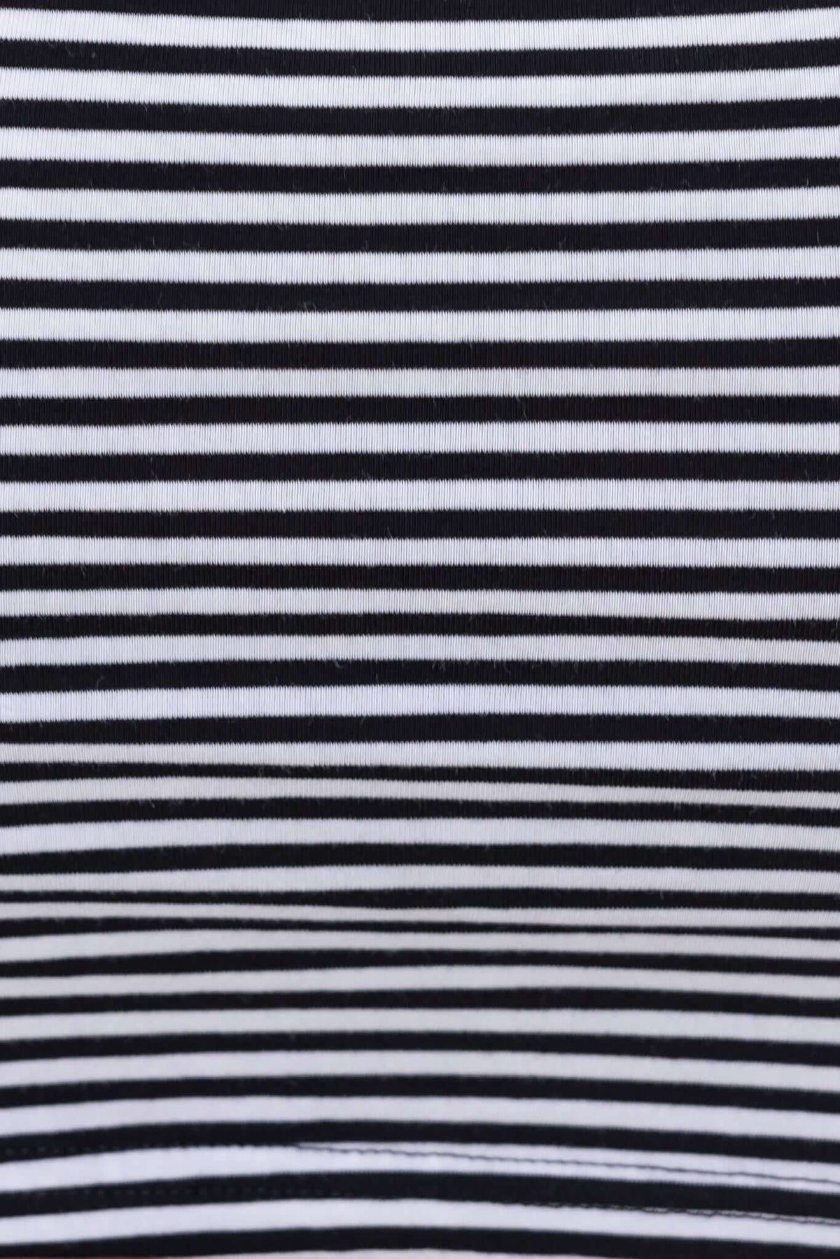 Close-up view of black and white striped fabric texture, ideal for creating stylish attire.