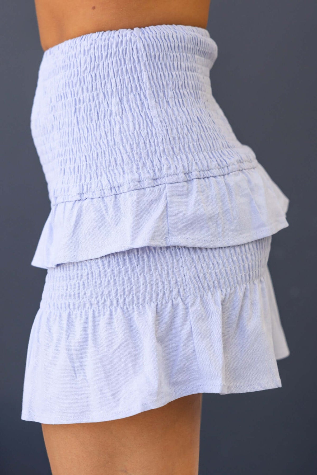 Nolan Skirt displayed in light blue with a mid-high waist, elastic fit, and ruffled layers.