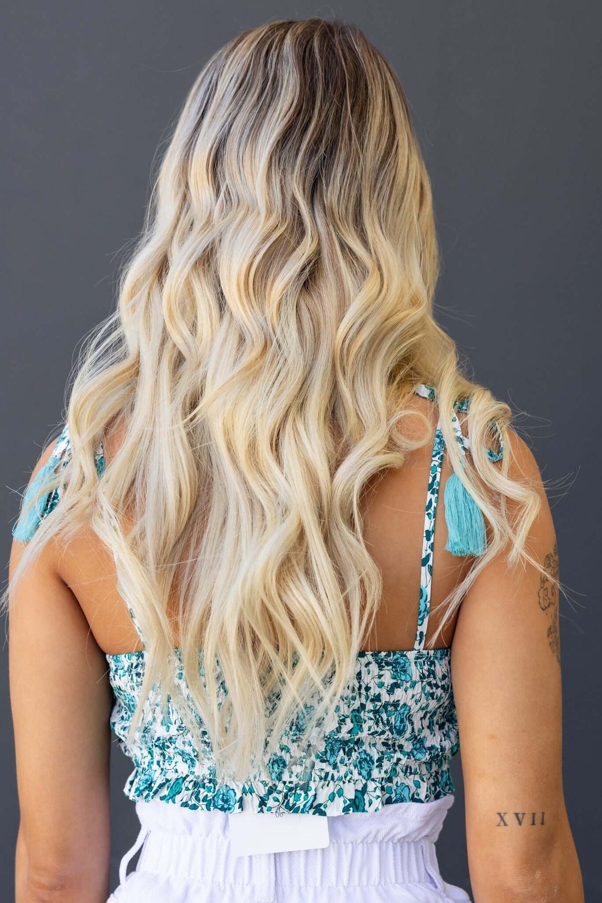 Back view of woman wearing Jana Top with tie straps and textured fabric, showcasing her long wavy blonde hair.