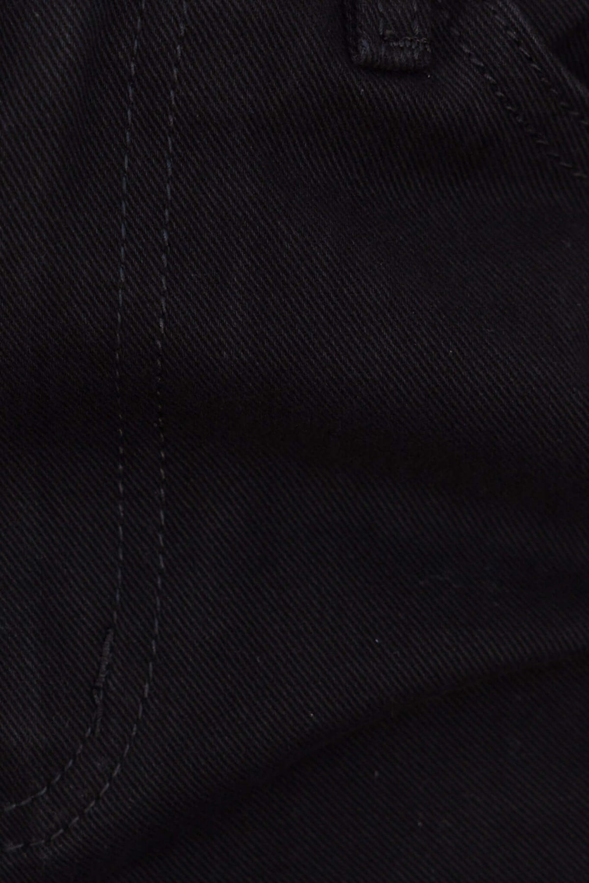 Close-up of black denim fabric with detailed stitching, showcasing the texture of Chandler jeans.