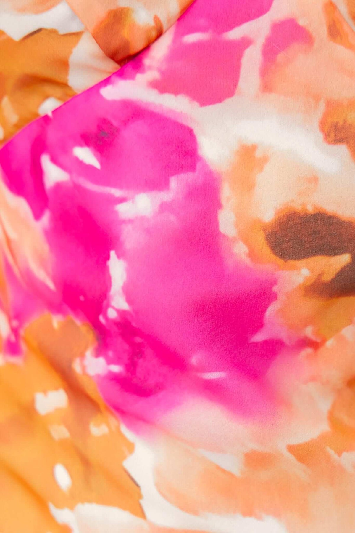 Close-up of the vibrant floral print in shades of pink and orange on the Qilax Maxi Dress.