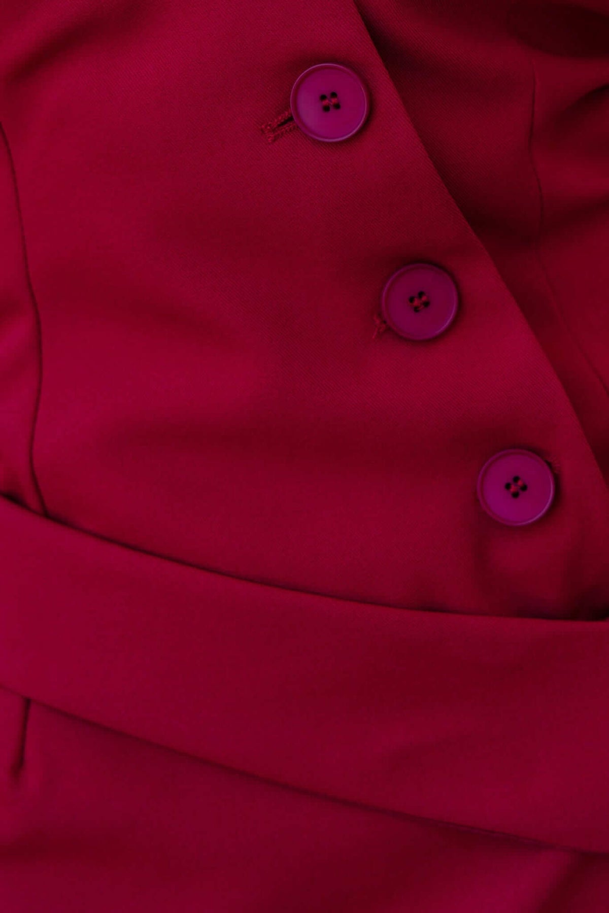 Close-up of Naia Playsuit showing bright pink fabric and button details.