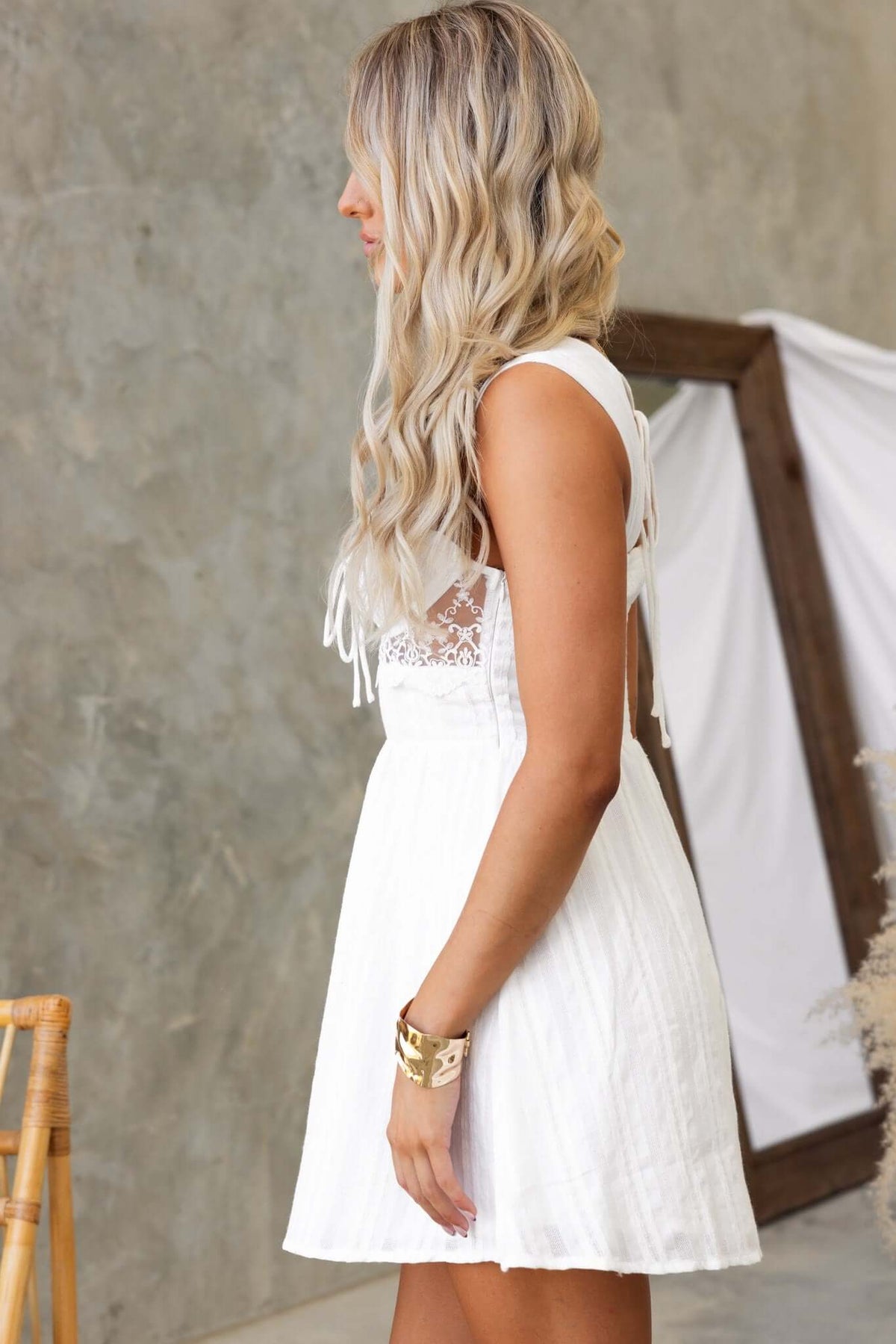 Side view of the Haizel Dress featuring a tie design at the bust and back, with a sheer panel under the bust.