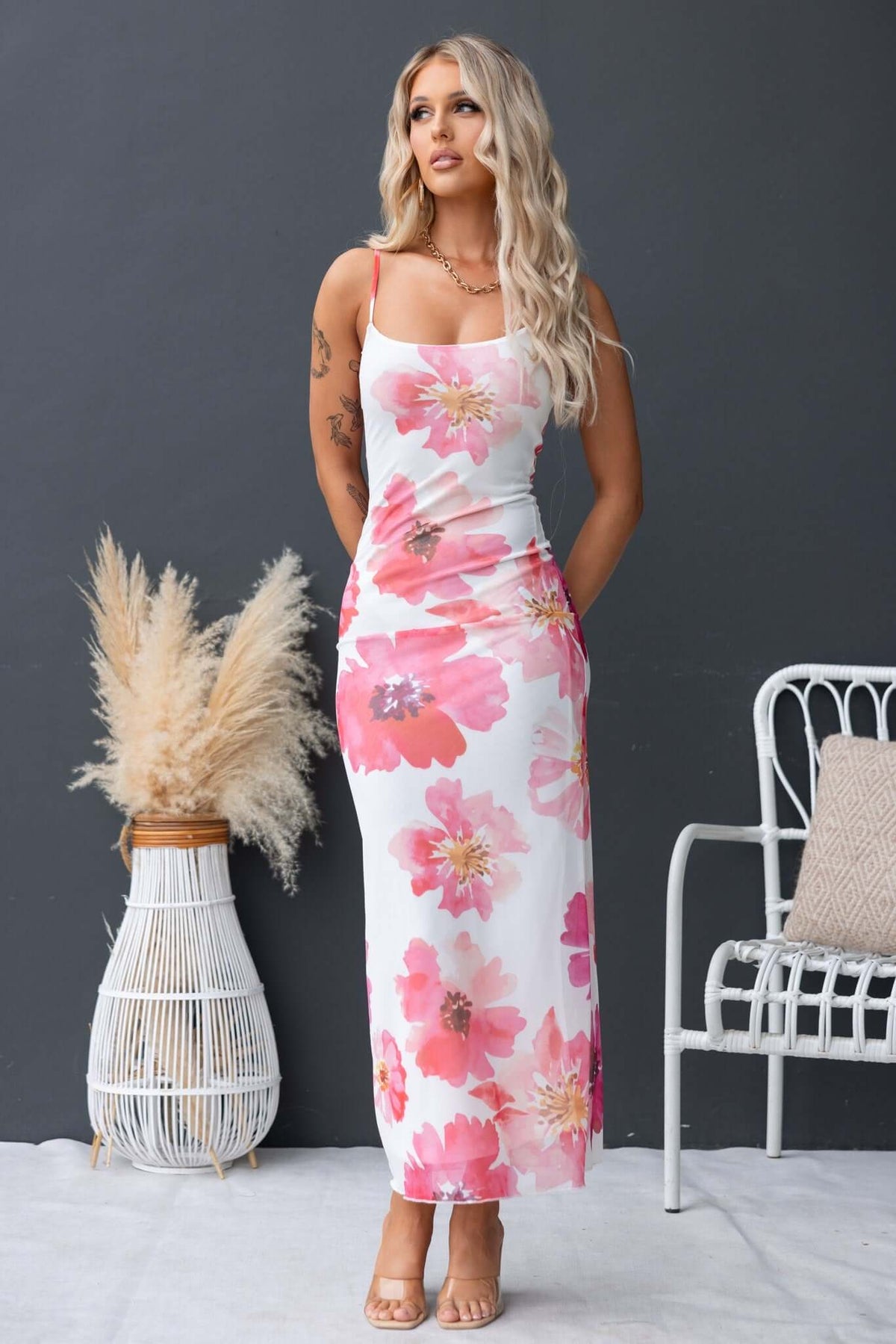 Model wearing the Manduria Maxi Dress featuring a floral print, adjustable straps, and a lined stretch material.