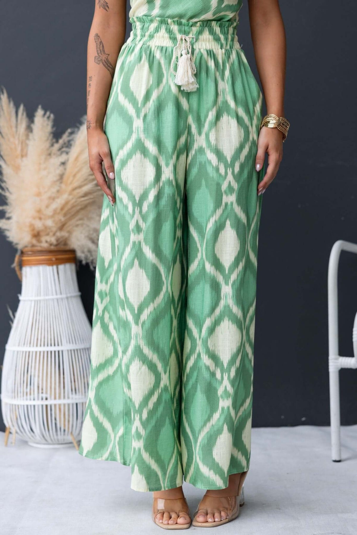 Model wearing Mason Pants in green with an elastic waistband and pockets, displayed against a stylish backdrop.
