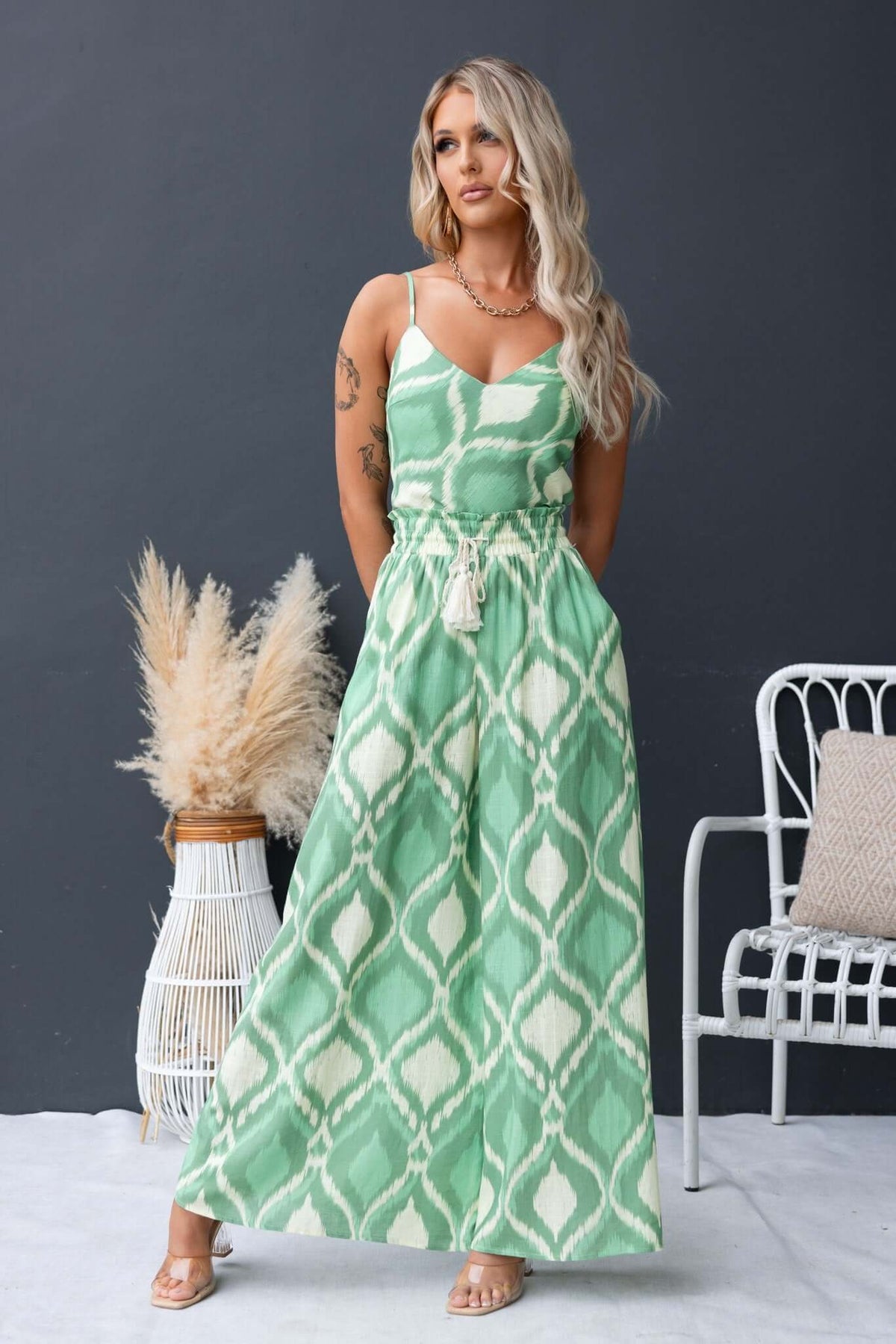 Model in green Mason Top dress with adjustable straps and intricate pattern, paired with boho accessories.