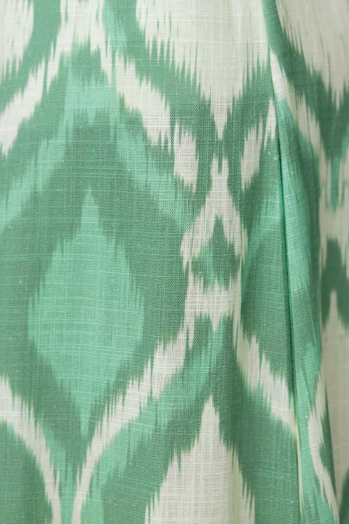 Close-up of green and white ikat pattern fabric, showcasing texture and design details of the Mason Pants.