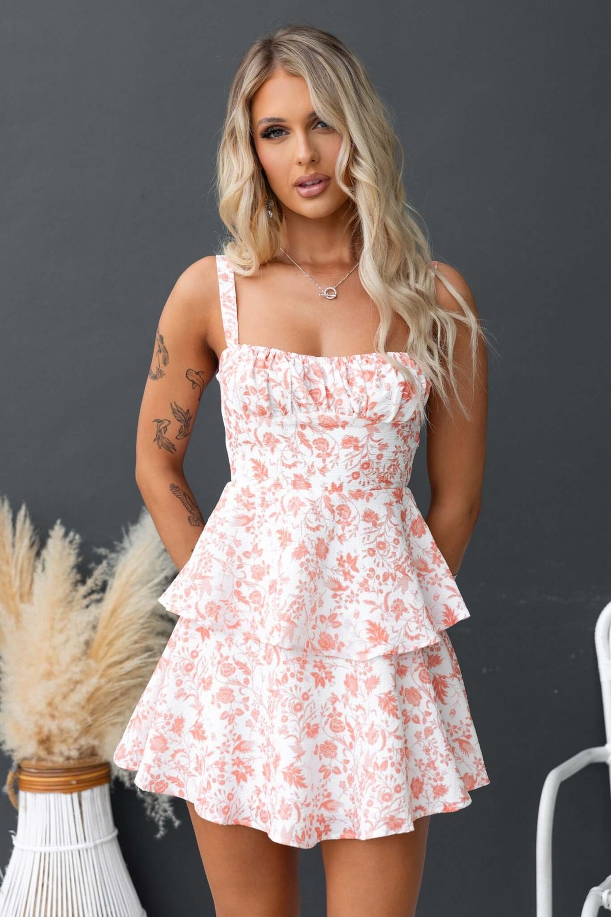 Floral print Peyton Dress with adjustable straps, peplum design, and a tie at the back, perfect for summer styling.
